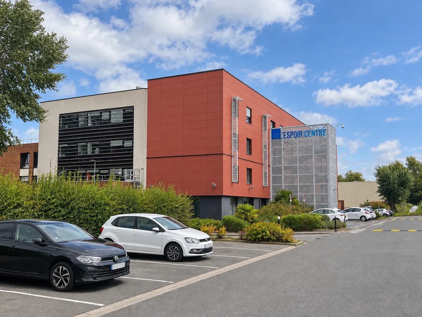 Centre de rééducation l'Espoir à Hellemmes, bâtiment à bardage rouge vu depuis le parking