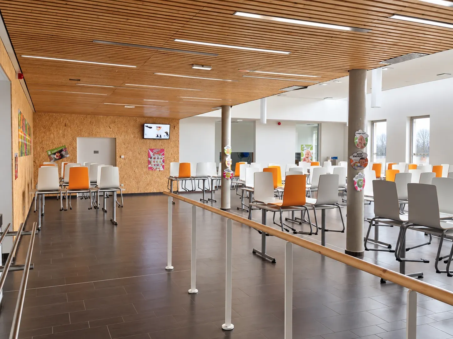 Salle de restauration du collège de Nieppe, plafond en lames de bois et chaises colorées