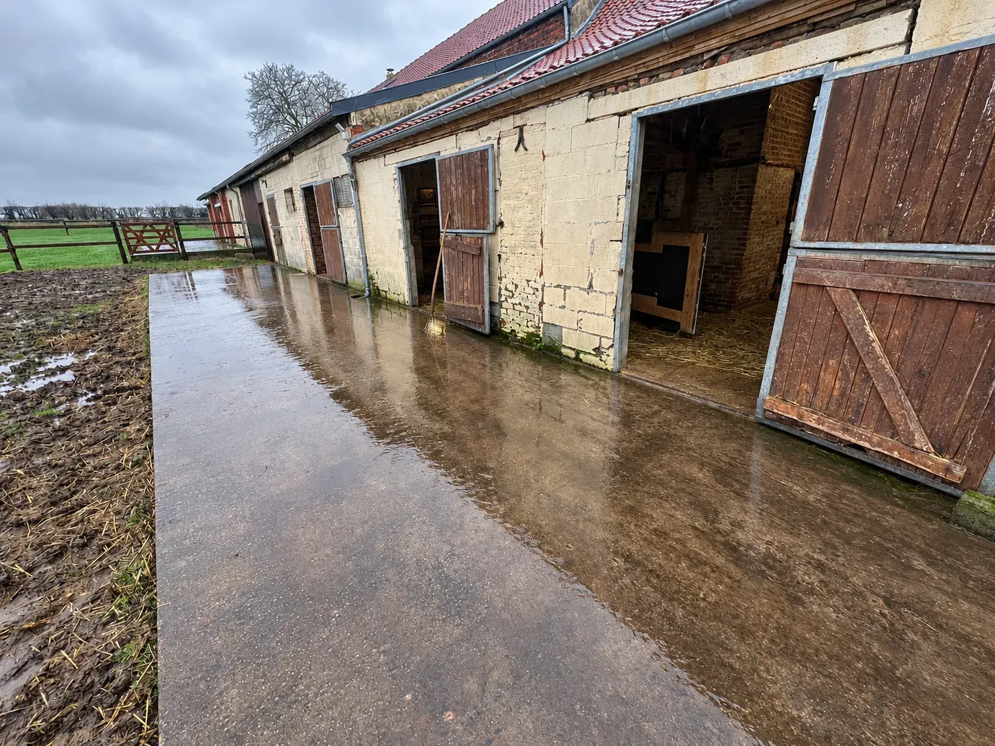 Dalle béton lissée devant les portes d'une écurie après le coulage