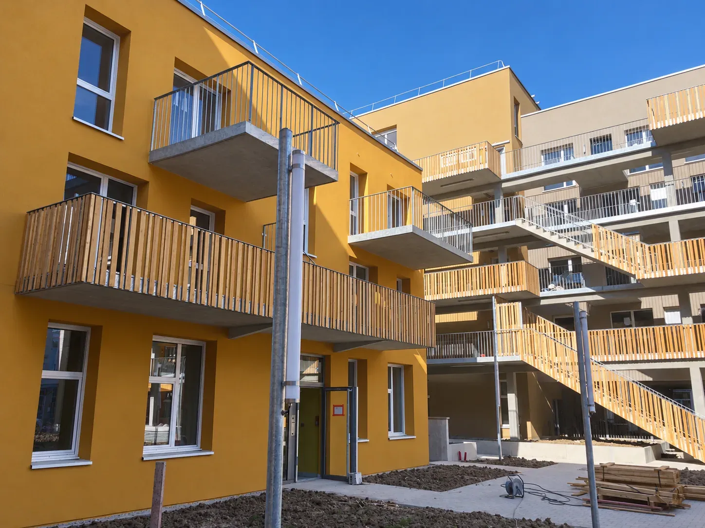 Façade jaune avec balcons en bois d'un immeuble de logements collectifs à Lille Wazemmes