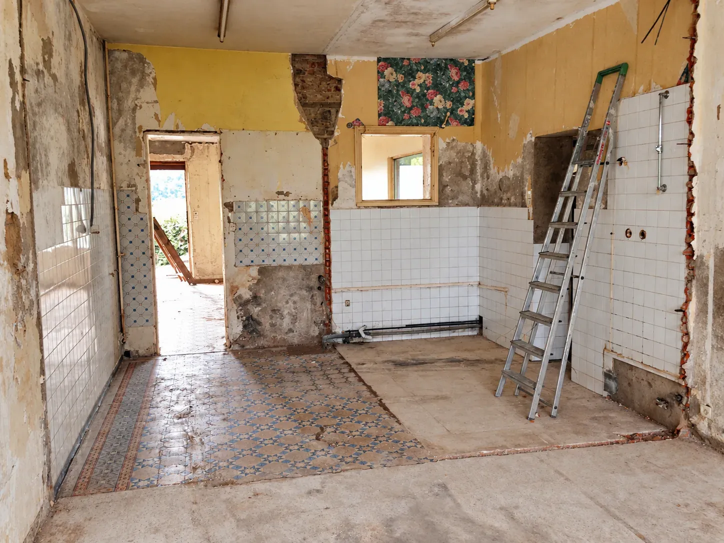 Salon en cours de démolition avant rénovation, ancien carrelage, faïence et murs bruts