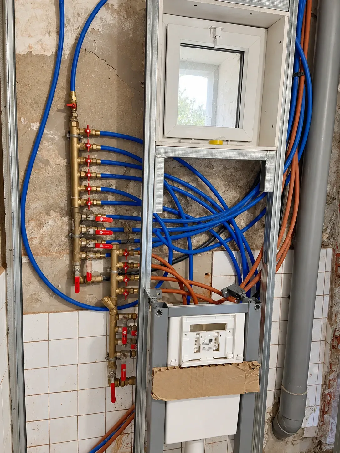 Plomberie avec nourrice et tubes PER et bâti-support du WC suspendu pendant les travaux